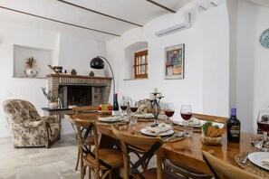 A dining area with a wooden table set for a meal, surrounded by chairs.