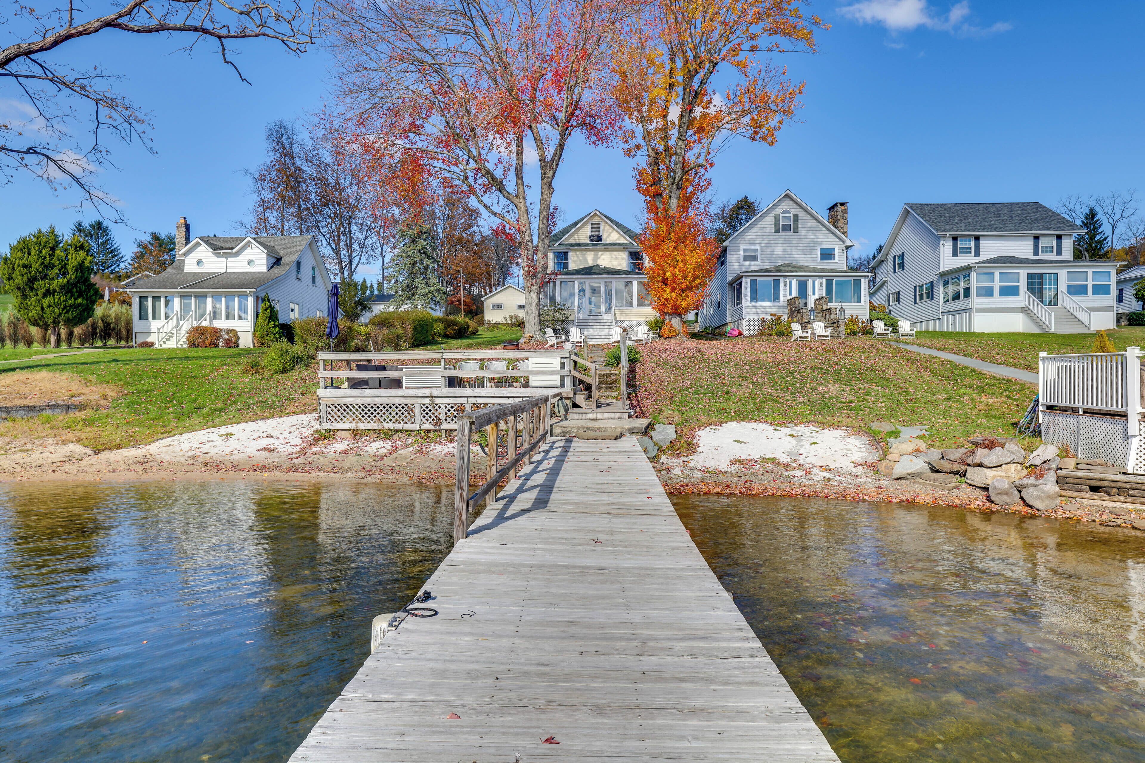 A wooden dock leading to a row of houses by a calm water body.