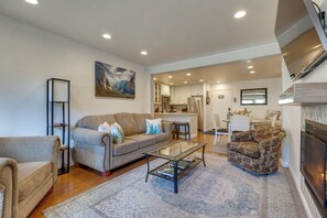A living room with a sofa, armchair, coffee table, and a fireplace. - Mammoth Mtn Ski-In/Out Condo w/ Hot Tub Access! (Mammoth Lakes)