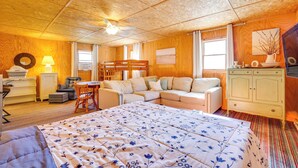 Une pièce confortable avec un grand lit, un canapé, une table à manger et un buffet.