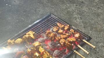 Una parrilla con diversas carnes y verduras asándose.