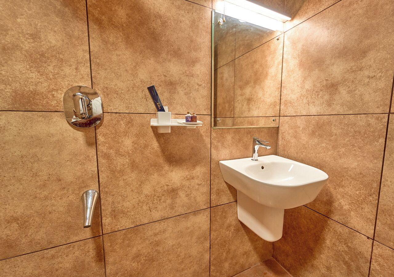 A bathroom with a white sink, a mirror, and a towel rack.