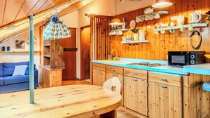 Eine gemütliche Küche mit Holzausstattung, einer blauen Arbeitsplatte und einem Esstisch.