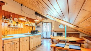 Ein Holzinnenraum mit Küche, Essbereich und Kamin.