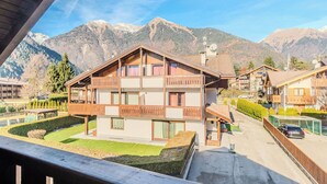 Ein mehrstöckiges Chalet mit Balkon, einem gepflegten Garten und Bergblick.