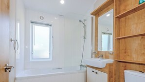 Une salle de bain équipée d’une baignoire, d’une douche, d’un lavabo et de toilettes.