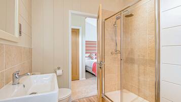 A bathroom with a sink, toilet, and shower.
