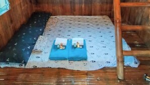 Une petite cabane en bois, avec un toit en pente, une seule fenêtre et une échelle.