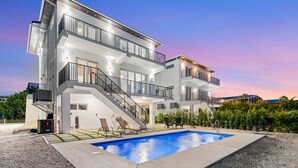 A modern multi-story building with a swimming pool, outdoor seating, and a staircase leading to the upper levels. - Copa D Oro 835 in Marathon (Marathon)