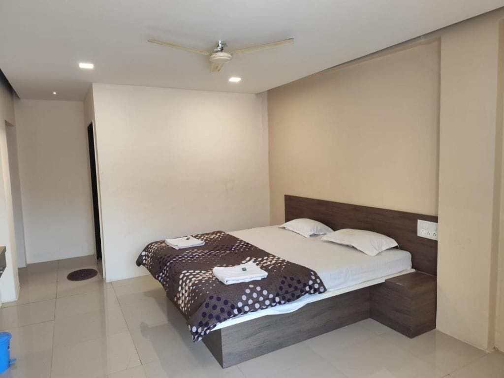 A bedroom with a bed, a ceiling fan, and a light switch on the wall.
