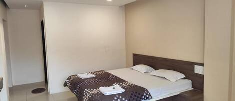A bedroom with a bed, a ceiling fan, and a light switch on the wall.
