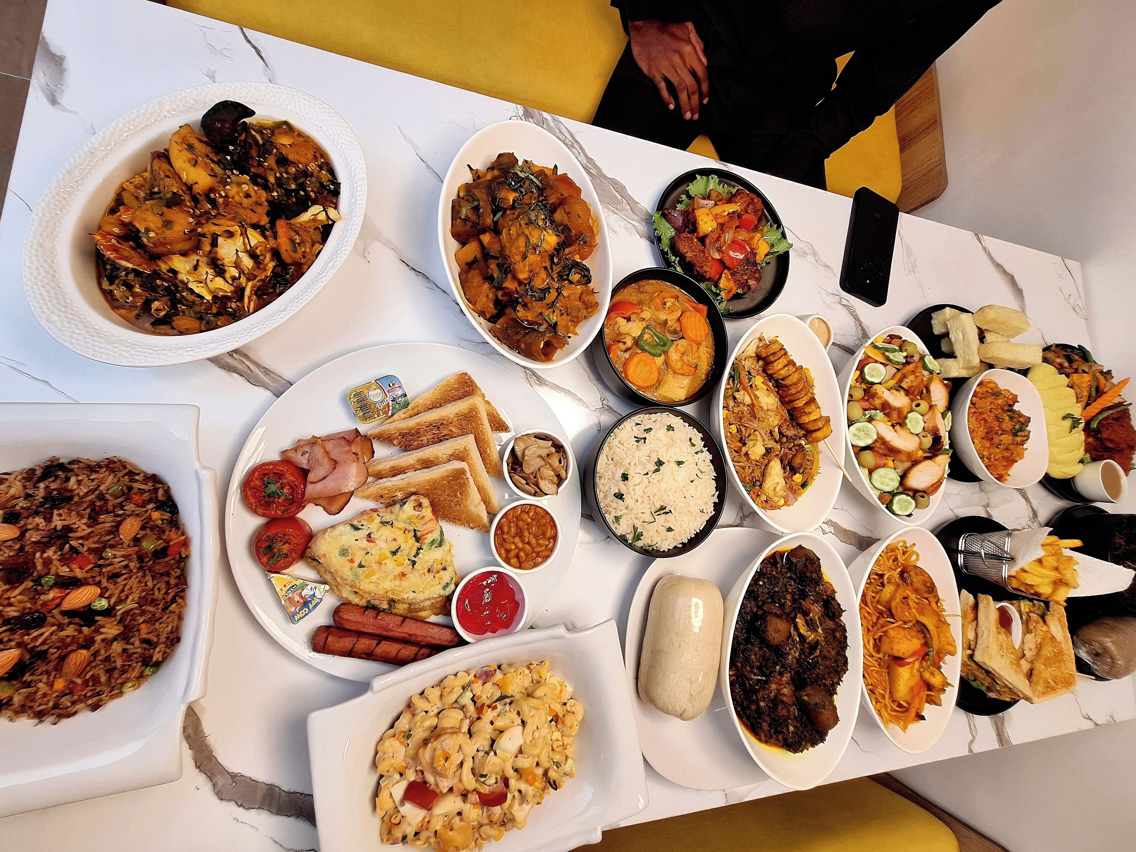 A table with various dishes including rice, bread, and meats.