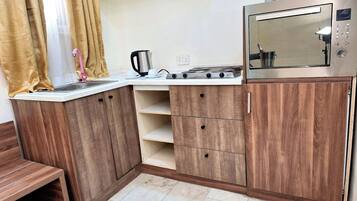 Luxury Suite, City View | Private kitchen | Mini-fridge, microwave, stovetop, cookware/dishes/utensils