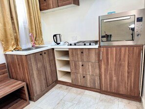 Luxury Suite, City View | Private kitchen | Mini-fridge, microwave, stovetop, cookware/dishes/utensils