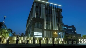 A modern hotel building with a prominent entrance and a sign that reads 'Emerald Luxe Boutique Hotel.' - Emerald Luxe A Boutique Hotel  (Mohali)