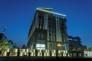 A modern hotel building with a prominent entrance and a sign that reads 'Emerald Luxe Boutique Hotel.' - Emerald Luxe A Boutique Hotel  (Mohali)