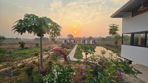A modern building with a pathway leading to a row of small cottages. - The Garden Resort  (Nong Rua)