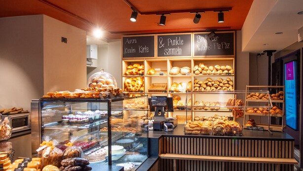 Une vitrine de boulangerie présentant diverses pâtisseries et une caisse enregistreuse.