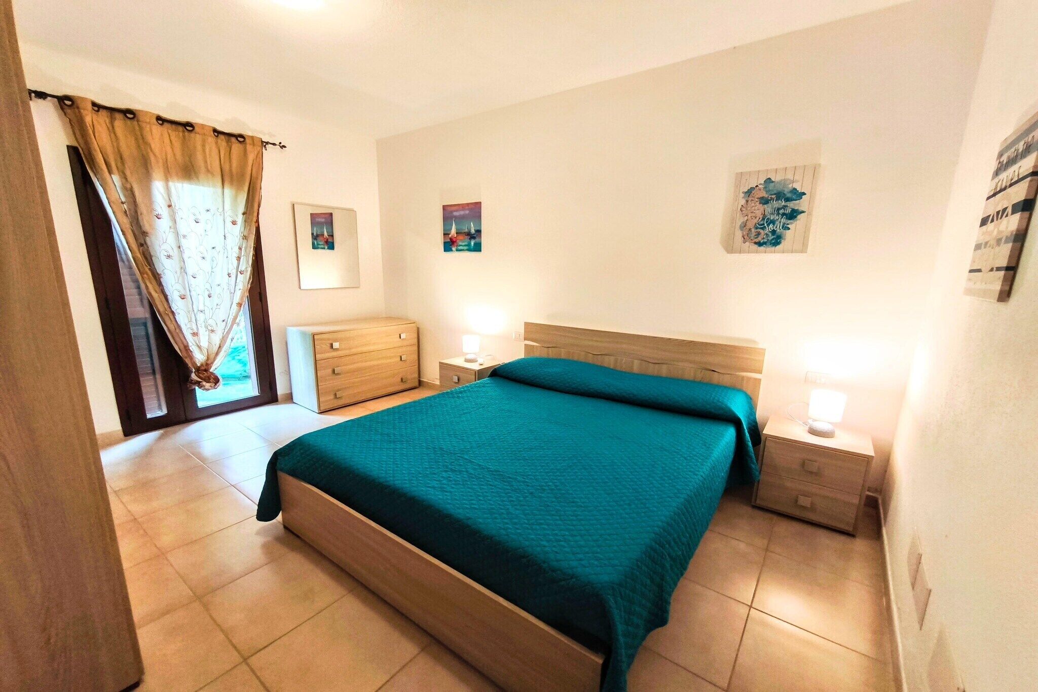 Un dormitorio con cama, cómoda de madera, mesitas de noche y decoración en la pared.