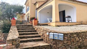 Un edificio con una escalera de piedra que conduce a un porche cubierto.