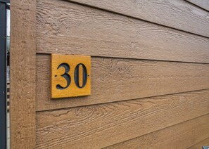 A wooden wall with a number plaque. - 4 bedroom accommodation in Bala, (Bala,)
