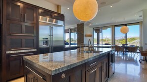 Una cocina moderna con armarios de madera oscura, electrodomésticos de acero inoxidable y una isla grande con encimera de granito.