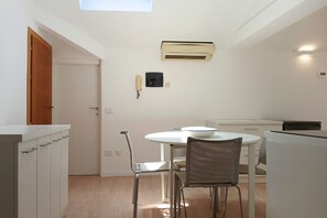 A compact kitchen with a round table, a white ceiling, and a built-in air conditioner. -  CV017 - Milano Marittima, elegant attic with air conditioning (Milano Marittima)