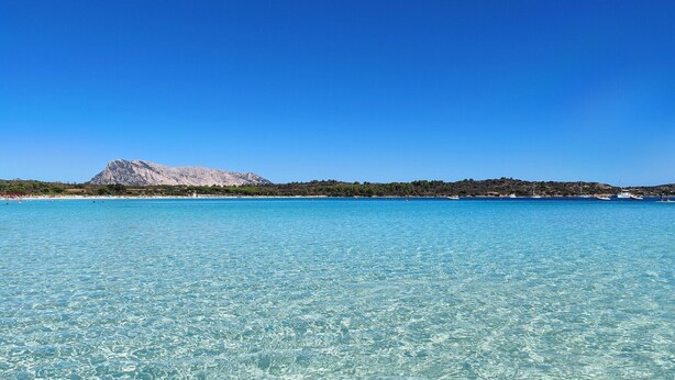 A clear blue sea with a mountain in the background. - Apartment with a sea-view terrace (Budoni)