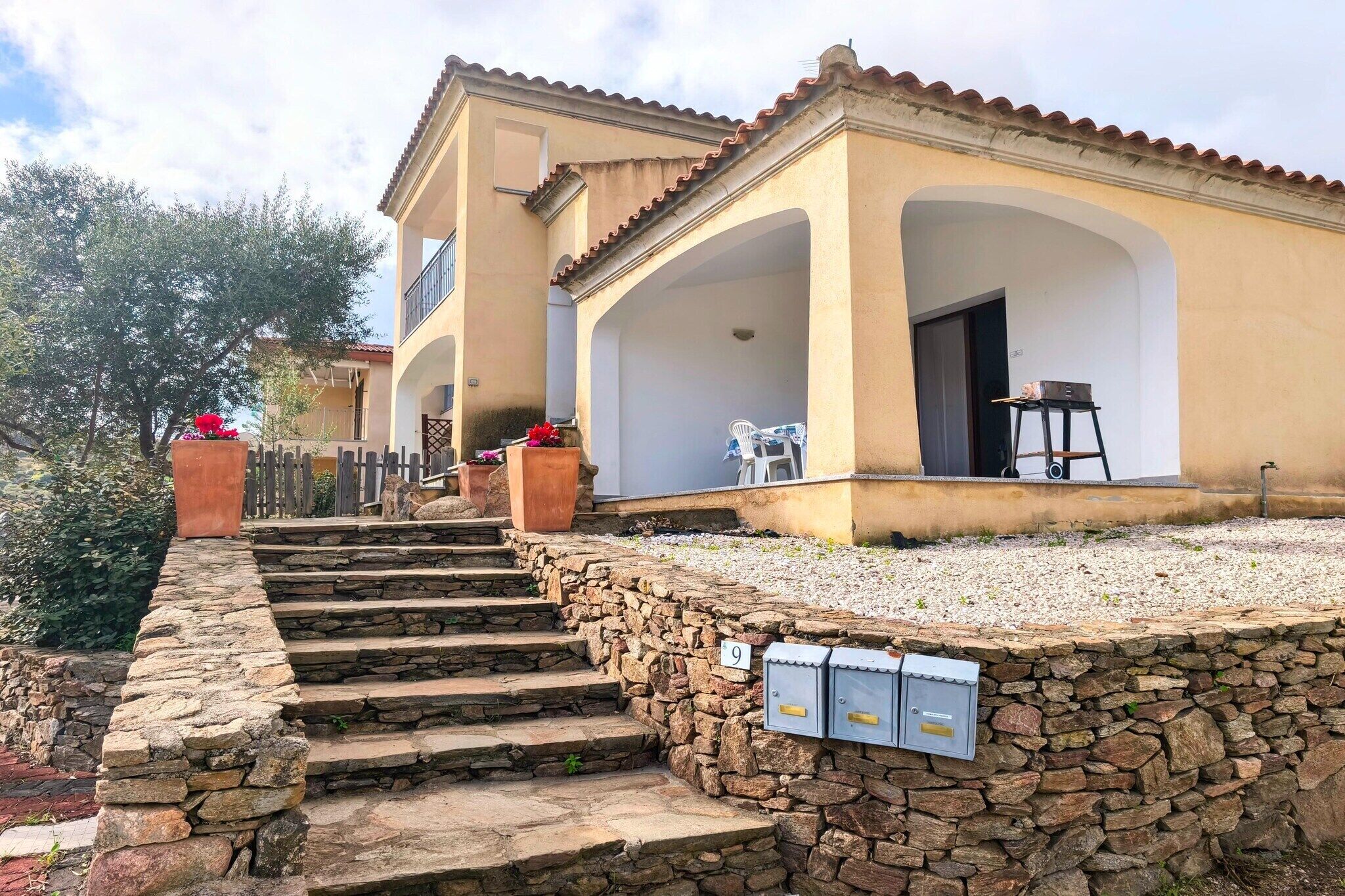 A building with a stone staircase leading to a covered porch area.