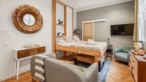 A compact bedroom with a bunk bed, a bedside table, a chair, a desk, a mirror, a TV, and a window with curtains. - Elegant Studio in 16th - Eiffel Tower & Trocadero (Paris)