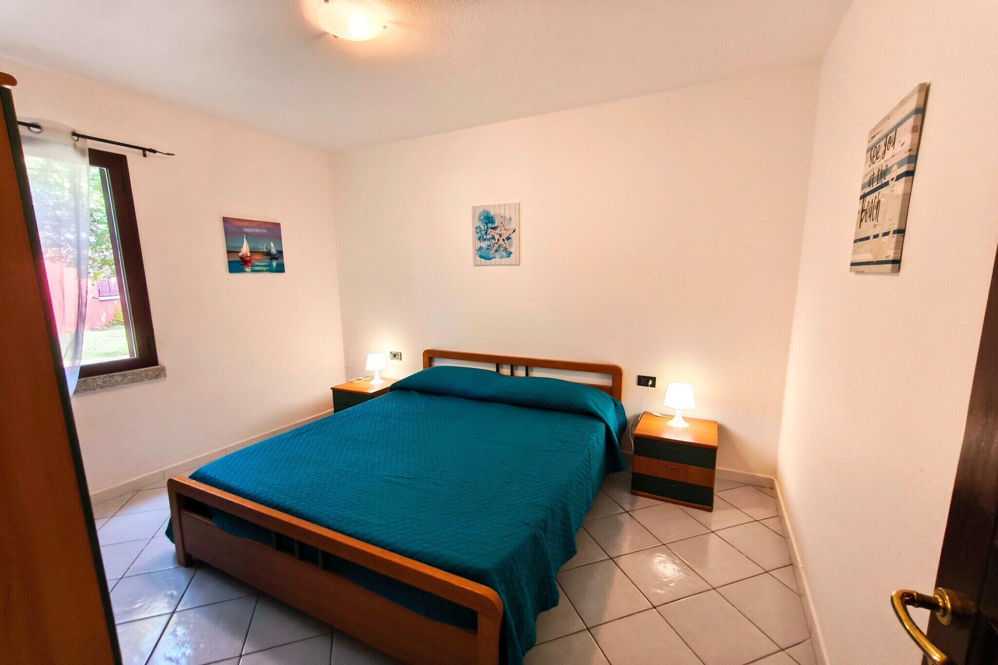 Ein Schlafzimmer mit einem Bett, Nachttischen und Kunstwerken an den Wänden.