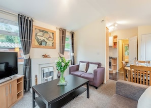 Ein Wohnzimmer mit Sofa, Couchtisch, Fernseher und Kamin.