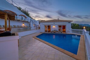 A pool area with a sunken seating area and a small building with a balcony. - Beautiful villa with pool and stunning view (Alicantie)