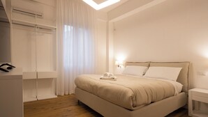A modern bedroom with a large bed, a bedside table, a wardrobe, and a ceiling light fixture. - Luxury Freedom Apollo (Palermo)