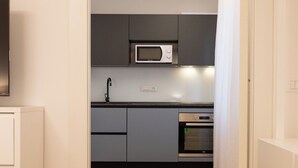 A modern kitchen with grey cabinets, a microwave, and an oven. - Luxury Freedom Apollo (Palermo)