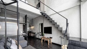 Ein modernes Interieur mit einer Treppe, einer Couch, einem kleinen Tisch und einer Küchenzeile.