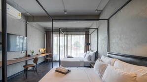 Una habitación de hotel moderna con una cama grande, un escritorio y un televisor.