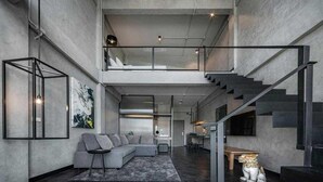 Amplia sala de estar con techo alto, una escalera y un diseño moderno.