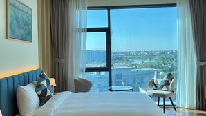Une chambre d’hôtel avec un grand lit, un bureau et une vue sur la ville.