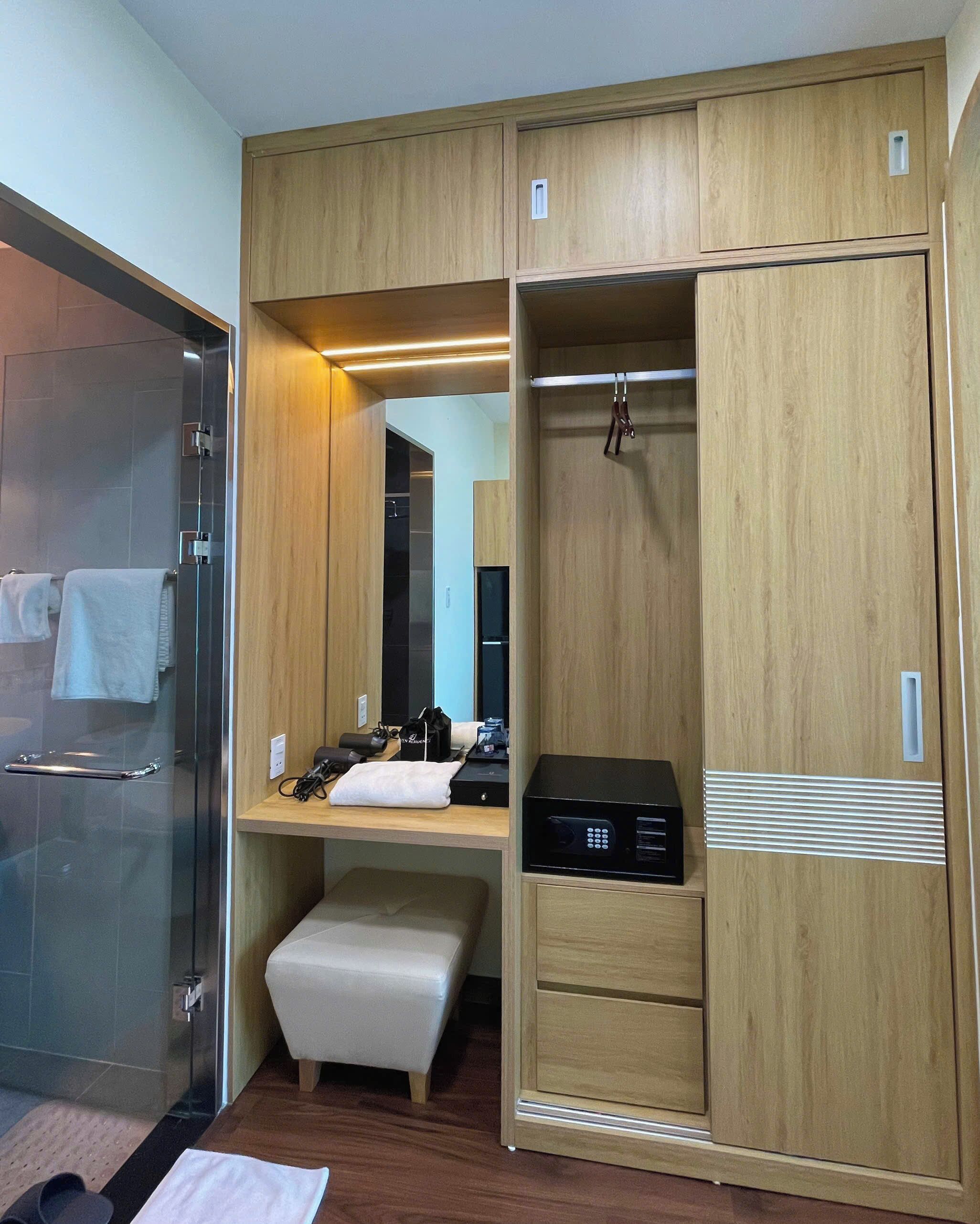 Ein modernes Badezimmer mit Glasdusche, Holzwaschtisch und Sitzbank.