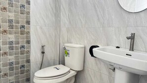 Un baño con inodoro, lavamanos y ducha.