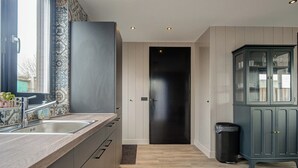 Een moderne keuken met een houten aanrecht, een spoelbak en een kast.