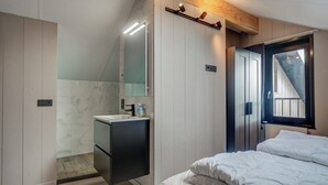 Een moderne slaapkamer met een bed, een inbouwkast, een spiegel en een raam.