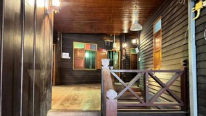 A wooden staircase leading to a porch with a railing, a wooden door, and a window with a green frame. - Social Male Dorm | Bed in 8-Bed Friendly Space (Chiang Mai)