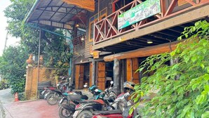 A building with a sign for 'Elephant Spa' and a restaurant. There are motorcycles parked in front. - Social Male Dorm | Bed in 8-Bed Friendly Space (Chiang Mai)