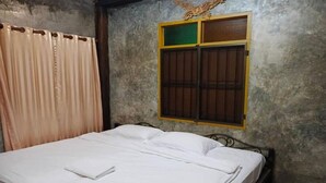 Ein Zimmer mit einem Bett, Vorhängen und einem Fenster mit einer Zierde.