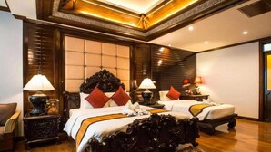 Una habitación de hotel con una cama grande, dos mesitas de noche y una alfombra estampada.