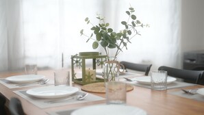 A dining table set with plates, cutlery, and a candle in a glass jar. - La Or Heritage Suites MRT Hua Lamphong (Bangkok)