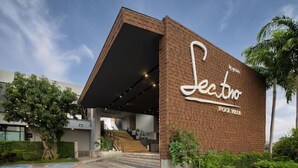 A modern building with a prominent sign reading "Sectro Pool Villa." - Spacious 3-Bedroom Family Pool Villa (Pattaya)