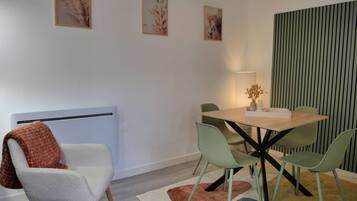 A modern dining area with a table, chairs, and a lamp.